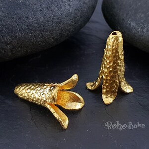 Puede incluir: Dos tapas de cuentas de metal de color dorado con textura martillada. Las tapas est&aacute;n dise&ntilde;adas para ser utilizadas como tapas finales para la elaboraci&oacute;n de joyas.