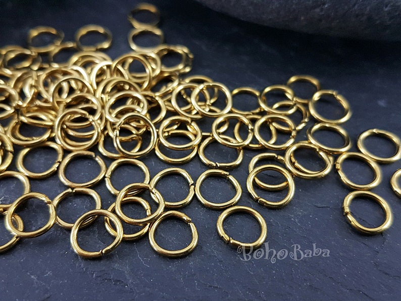 May include: A large pile of gold jump rings. The rings are small and round, and they are perfect for jewelry making.