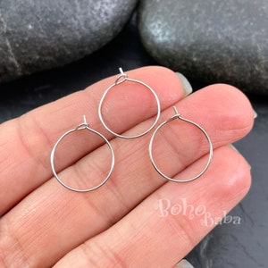 Puede incluir: Tres pendientes de aro de plata con un diseño sencillo. Los aros son pequeños y delicados, perfectos para el uso diario.