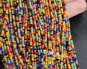 May include: A close-up of a strand of colorful seed beads. The beads are small and round, and they are arranged in a repeating pattern of red, orange, yellow, blue, green, and black. The beads are strung on a clear thread.