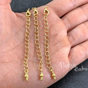 May include: Three gold chain extenders with lobster claw clasps and decorative ball ends.