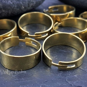 May include: A set of eight gold-toned metal rings with a split design. The rings are open and can be adjusted to fit different finger sizes.