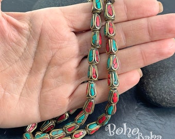 May include: Two strands of beads with a brass finish and red and turquoise inlay. The beads are teardrop shaped and have a decorative design.