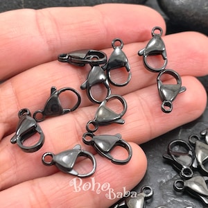Puede incluir: Una colección de cierres de langosta de color plomo. Estos cierres metálicos cuentan con un mecanismo de resorte para un cierre seguro. Los cierres están diseñados para la fabricación de joyas y otros proyectos de artesanía. La imagen muestra varios cierres.