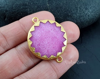 Peut inclure: Pendentif rond de couleur or avec un centre rose texturé et un motif en étoile autour du bord. Le pendentif a deux boucles pour attacher une chaîne.