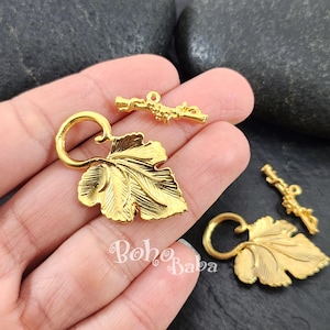 Può includere: Chiusure a forma di foglia in metallo dorato con un design a vite. Le chiusure sono perfette per aggiungere un tocco di eleganza a gioielli o altri oggetti artigianali.