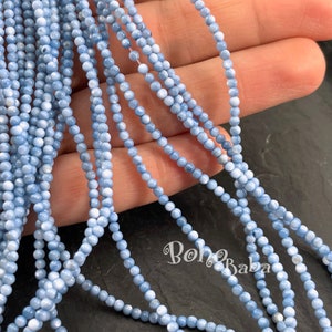 May include: A strand of light blue opal beads, approximately 4mm in diameter. The beads are round and have a smooth, polished finish. The strand is approximately 16 inches long.