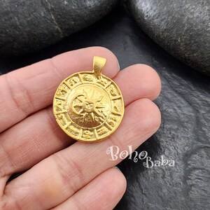 May include: Gold-toned zodiac pendant featuring a sun and moon design with the astrological signs around the perimeter.