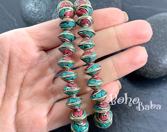 May include: Long, dangling earrings featuring alternating turquoise and red stone beads, encased in gold-toned wire. The beads are arranged in a vertical line, creating a striking visual effect. The earrings are a bohemian style.