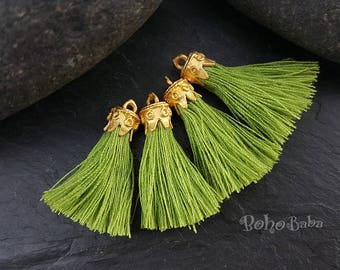 May include: Four green tassel trim with gold metal tops. The tassels are made of soft, fine threads and are perfect for adding a touch of elegance to any project.
