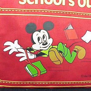 Puede incluir: Bolsa de tela roja con un borde cosido amarillo. La bolsa presenta una imagen de dibujos animados de Mickey Mouse corriendo con libros y papeles volando detr&aacute;s de &eacute;l. El texto "School's Out!" es visible en la parte superior de la bolsa.