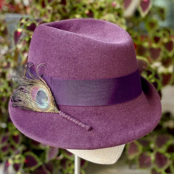 Amethyst purple velour felt fedora with upturned brim, ribbon band, and dyed peacock feather
