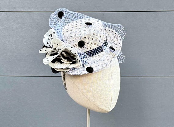 White and black polka dot straw mini brimmed perching hat with silk flowers on headband