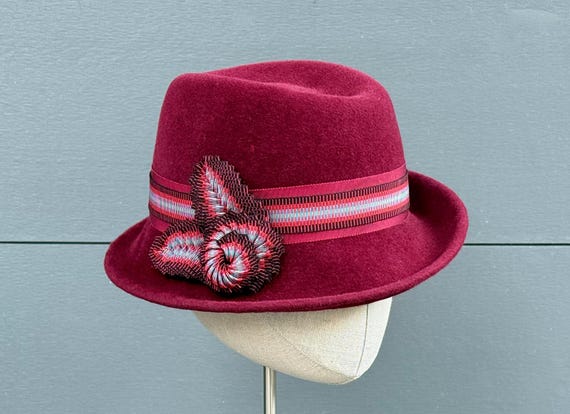 Cranberry velour felt women's fedora with striped ribbon band and cockades