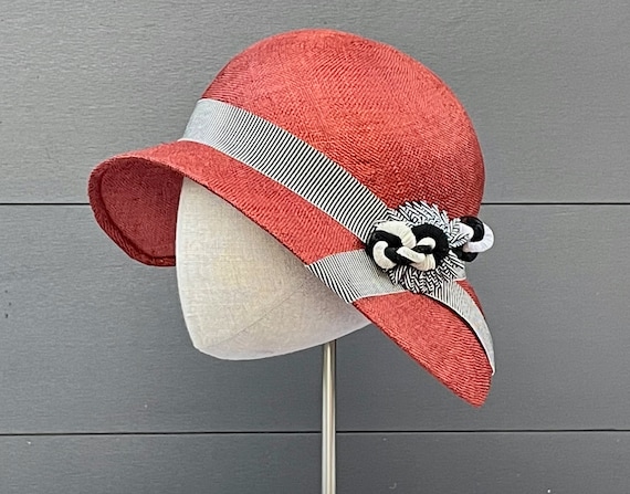 Rust sisal straw cloche hat with black and white striped ribbon band and cockade and vintage straw ornament