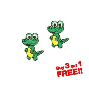 May include: Two green embroidered iron-on patches of cartoon crocodiles with big eyes. The crocodiles are standing with their mouths closed. The text "Buy 3 get 1 FREE!!" is in red letters below the patches.
