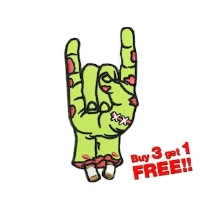 Op de afbeelding: Groene zombiehand die de rock-and-roll handbeweging maakt. De hand heeft rode hechtingen en rode bloedvlekken. De hand is op een witte achtergrond. De tekst "Buy 3 get 1 FREE!!" staat in rode letters.