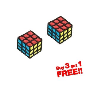 Peut inclure: Deux patchs brodés à repasser représentant un cube de Rubik rouge, bleu et jaune. Le texte "Buy 3 get 1 FREE!" est situé sous les patchs.