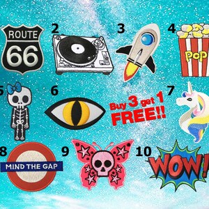 Puede incluir: Diez parches termoadhesivos coloridos con varios diseños, incluyendo un letrero de la Ruta 66, un tocadiscos, un cohete, un cubo de palomitas de maíz, un esqueleto, un ojo, un unicornio, un letrero del metro de Londres, una mariposa con una calavera y una burbuja de diálogo de estilo cómic "WOW!" Los parches están numerados del 1 al 10.