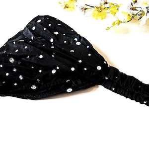 Può includere: Fascia nera con paillettes argentate. La fascia è realizzata in un tessuto morbido ed elastico.