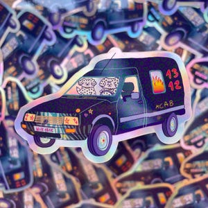 Op de afbeelding: Een holografische sticker van een donker busje met een luipaardprint. Het busje toont twee witte honden op de voorstoelen, een vlammenafbeelding op het zijraam, de tekst 13 12 en ACAB, en een kentekenplaat met de tekst Nik 1512.