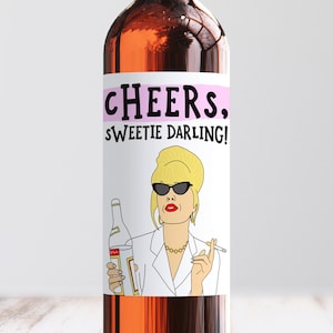 May include: Wine bottle label featuring a cartoon illustration of a woman with blonde hair, sunglasses, and a cigarette in her hand. The text on the label reads "CHEERS. SWEETIE DARLING!"
