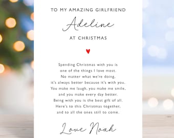 May include: A white greeting card with black script that reads "TO MY AMAZING GIRLFRIEND Adeline AT CHRISTMAS." A red heart is centered above a poem. The card is signed "Love Noah."