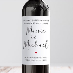 May include: A white wine bottle label with the text "Congratulations on your 1st Wedding Anniversary Maisie and Michael" and a small red heart.