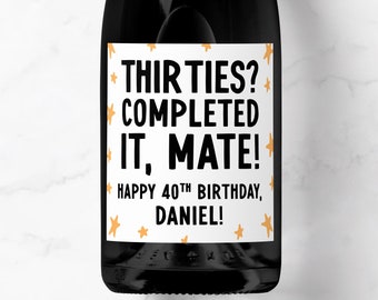 May include: A white wine bottle label with black text that reads "Thirties? Completed it, mate! Happy 40th Birthday, Daniel!" with orange stars on a white background.