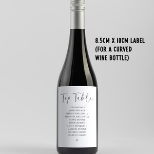May include: A black wine bottle with a silver cap and a white label. The label reads "Top Table" and lists names. The text "8.5cm x 10cm label (for a curved wine bottle)" is also visible.