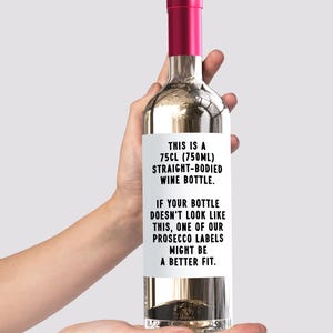 May include: A white wine bottle with a black and white label that reads "THIS IS A 75CL (750ML) STRAIGHT-BODIED WINE BOTTLE. IF YOUR BOTTLE DOESN'T LOOK LIKE THIS, ONE OF OUR PROSECCO LABELS MIGHT BE A BETTER FIT."
