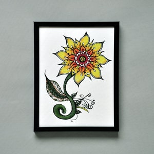 May include: A framed watercolor painting of a yellow and orange sunflower with intricate details in the center. The sunflower is drawn with a black outline and has a green stem and leaves.