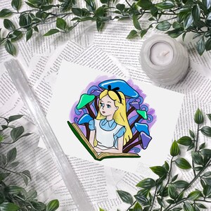 Puede incluir: Una ilustraci&oacute;n de acuarela de Alicia en el Pa&iacute;s de las Maravillas sentada bajo un hongo leyendo un libro. La ilustraci&oacute;n est&aacute; en tonos de morado, azul y verde.