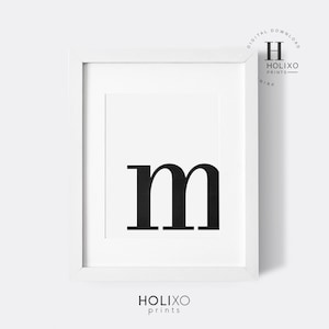 May include: A black and white printable wall art design featuring the letter "m" in a bold, modern font. The letter is centered on a white background within a white frame.