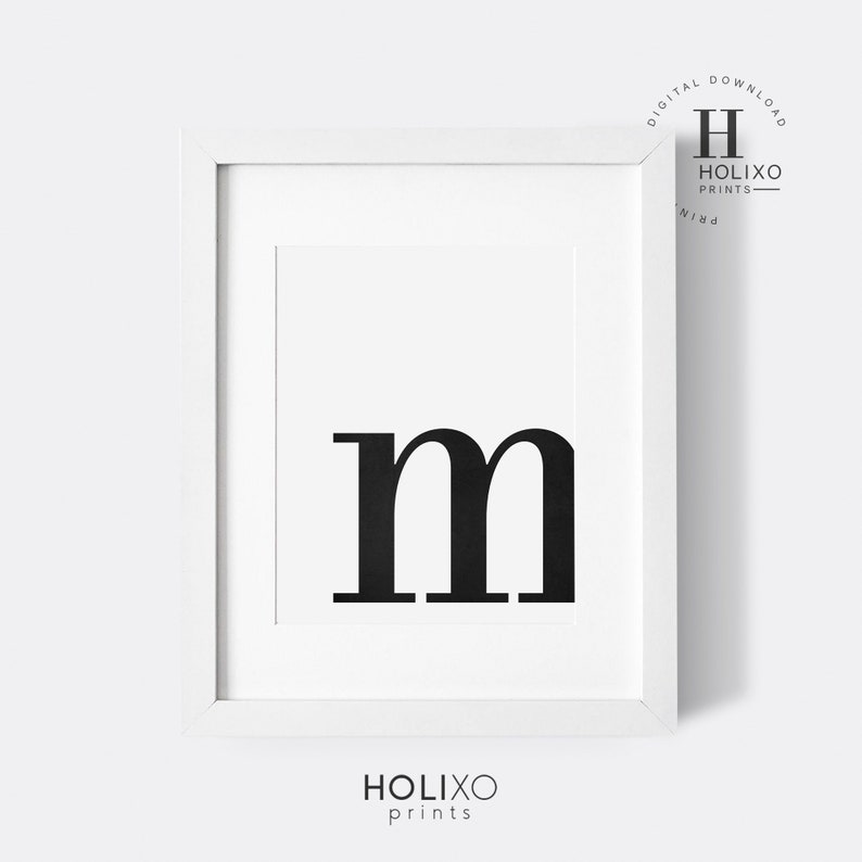 May include: A black and white printable wall art design featuring the letter "m" in a bold, modern font. The letter is centered on a white background within a white frame.