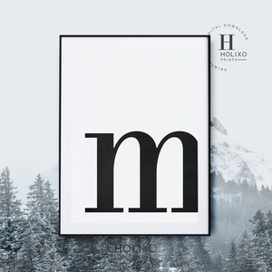 May include: Black and white printable wall art featuring the letter "m" in a bold, sans-serif font. The letter is centered on a white background within a black frame.