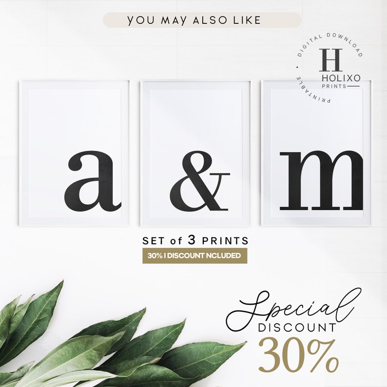 May include: Set of three black and white printable wall art prints featuring the letters "a", "&", and "m" in a bold, modern font. The prints are framed in white and displayed on a white wall. The text "SET of 3 PRINTS" and "30% DISCOUNT INCLUDED" is visible below the prints. The text "Special DISCOUNT 30%" is visible in a handwritten font below the prints.