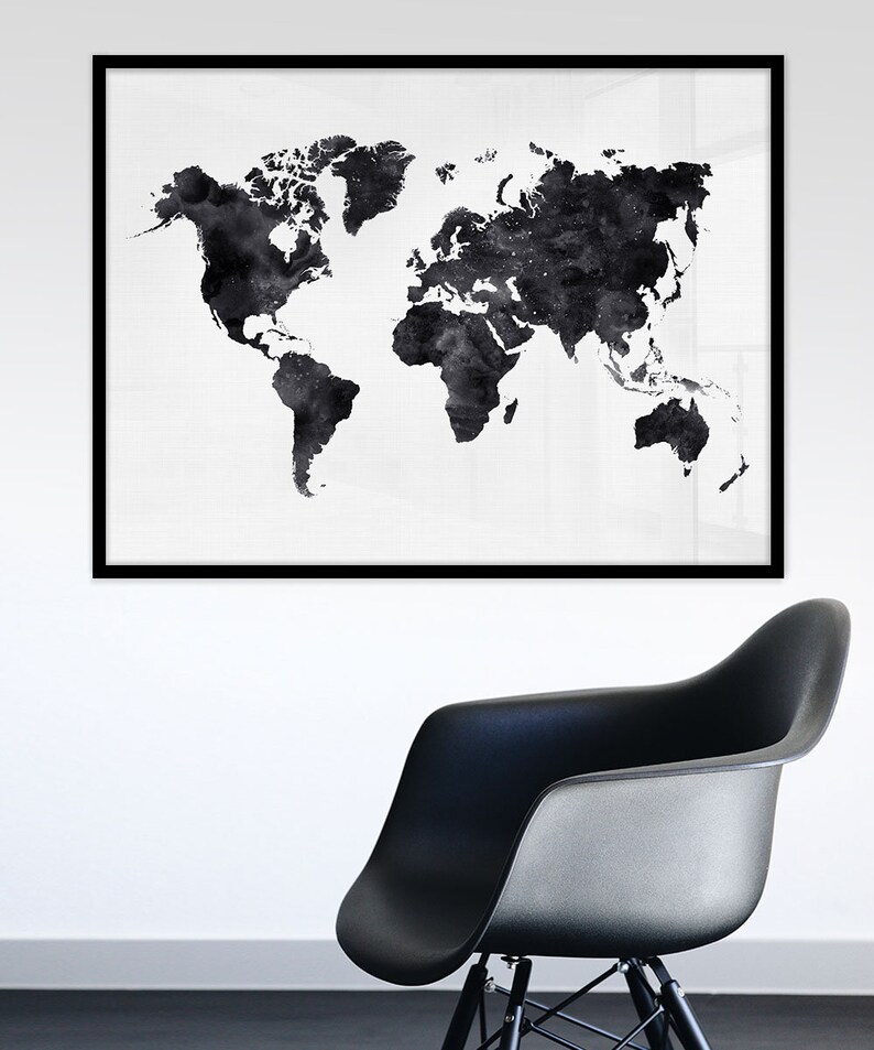 Puede incluir: Una impresi&oacute;n de mapa del mundo en acuarela en blanco y negro en un marco negro que cuelga de una pared blanca sobre una silla negra.