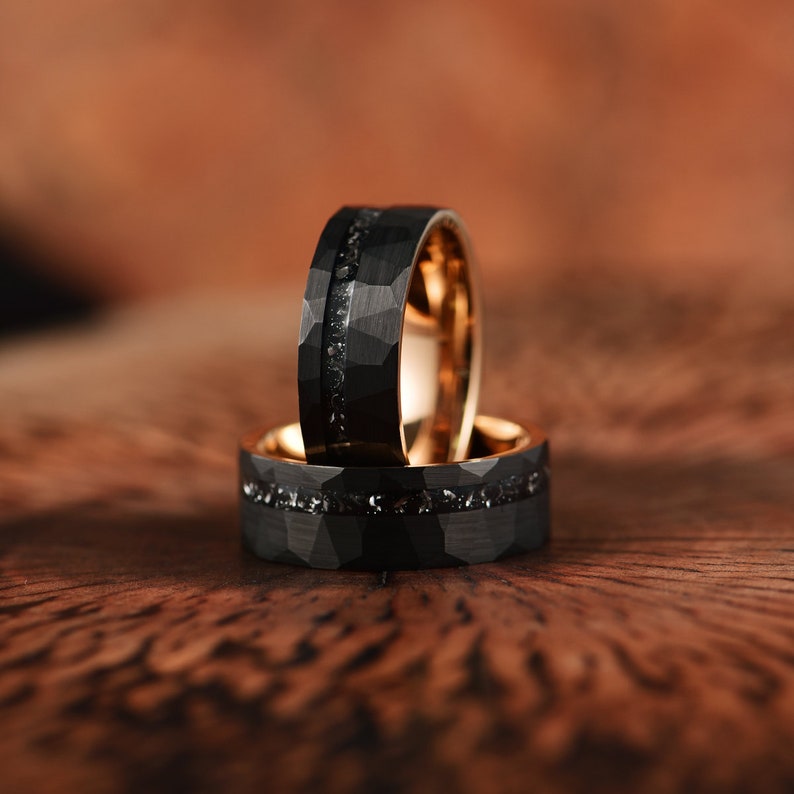 Meteorite mens wedding band crafted in meteorite hammered black tungsten and rose tungsten with a flat profile and a comfort fit interior. Rings By Pristine