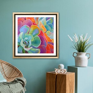 May include: Close-up of a colorful succulent plant with vibrant green, blue, purple, orange, and red hues. The succulent is framed in a brown wood frame.