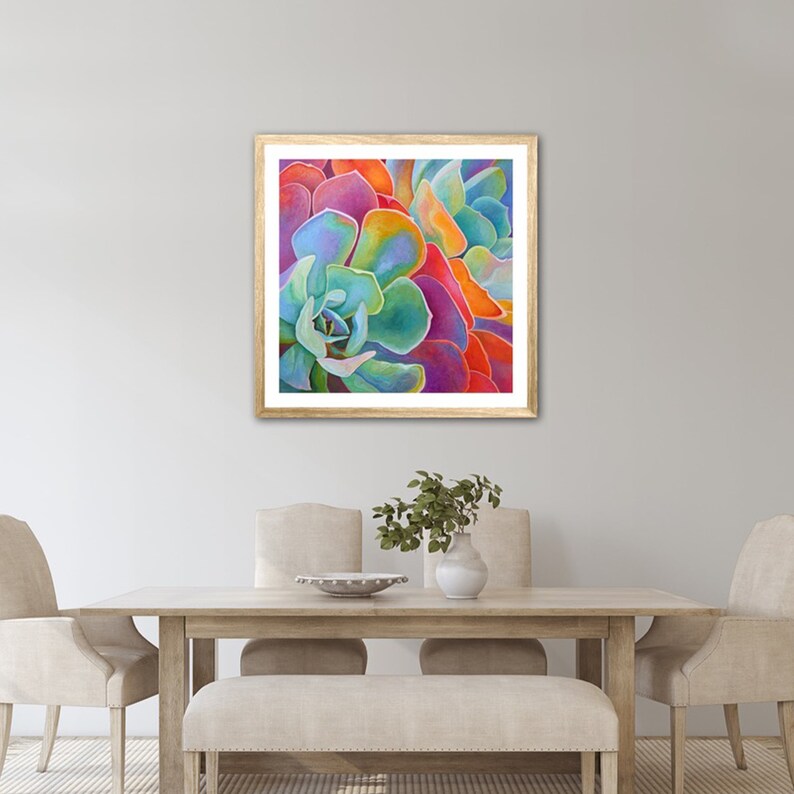 May include: Close-up of a vibrant succulent with overlapping petals in shades of blue, green, purple, orange, and red. The succulent is framed in a light wood frame.