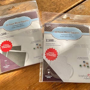 May include: Two packages of 3D foam micro squares, one black and one white. Each package contains 2,508 pieces and is labeled "Scrapbook Adhesives".