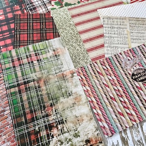 May include: A collection of patterned paper sheets with various designs, including plaid, stripes, floral, and musical notes. Colors include red, green, white, and beige. Some sheets feature Christmas-themed patterns, such as poinsettias and candy canes. The text "World Famous Candies" is visible.