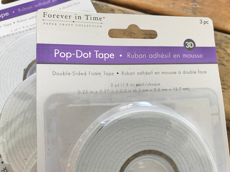 May include: A package of 3 double-sided foam tape rolls, labeled "Pop-Dot Tape" and "Ruban adh&eacute;sif en mousse". Each roll is 2 yards (1.8 meters) long and measures 0.25 inches (6.3 mm) wide.