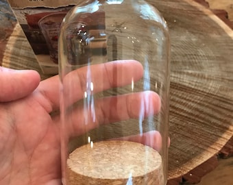 Peut inclure: Un dôme de présentation en verre transparent avec une base en liège. Le dôme mesure environ 15 cm de haut et 10 cm de large. Le dôme est parfait pour présenter de petits objets, comme des figurines, des bijoux ou d'autres objets de collection.