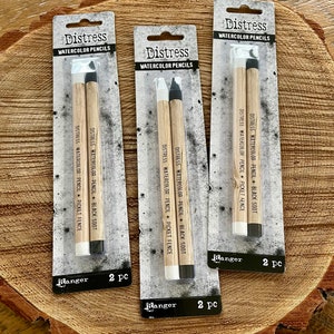 May include: Three packages of Distress Watercolor Pencils, each containing two pencils. The pencils are labeled "Distress Watercolor Pencil" and "Picket Fence" and "Black Soot". Each package is labeled "Ranger" and "2 pc".