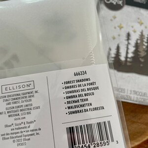 May include: A white package with a barcode and product information for a set of forest shadows dies. The package includes the product name, product number, and a list of languages for the product name. The product is made by Ellison Educational Equipment, Inc. and is part of the Sizzix brand.