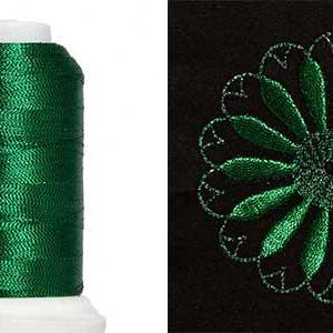 May include: A spool of emerald green embroidery thread next to a close-up of a green floral embroidery design on black fabric. The thread is on a white spool. The floral design is a stylized flower.