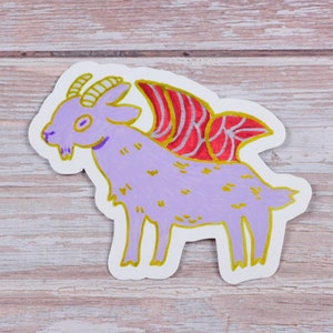 May include: A purple goat with gold horns and hooves, with red and gold wings, is illustrated on a white sticker.