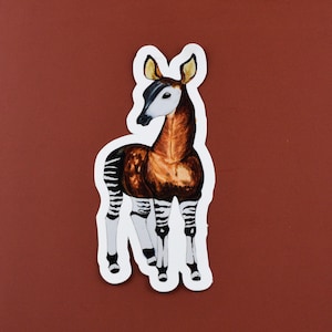 May include: A sticker featuring a watercolor illustration of an okapi, a mammal native to the Democratic Republic of Congo. The okapi has a brown and white striped body, a long neck, and a dark muzzle.